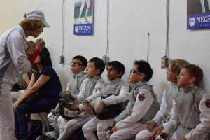 Coach preparing youth fencers to competition