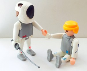 Fencer helps another fencer that is injuired during the fencing bout (LEGO fencers figurines)